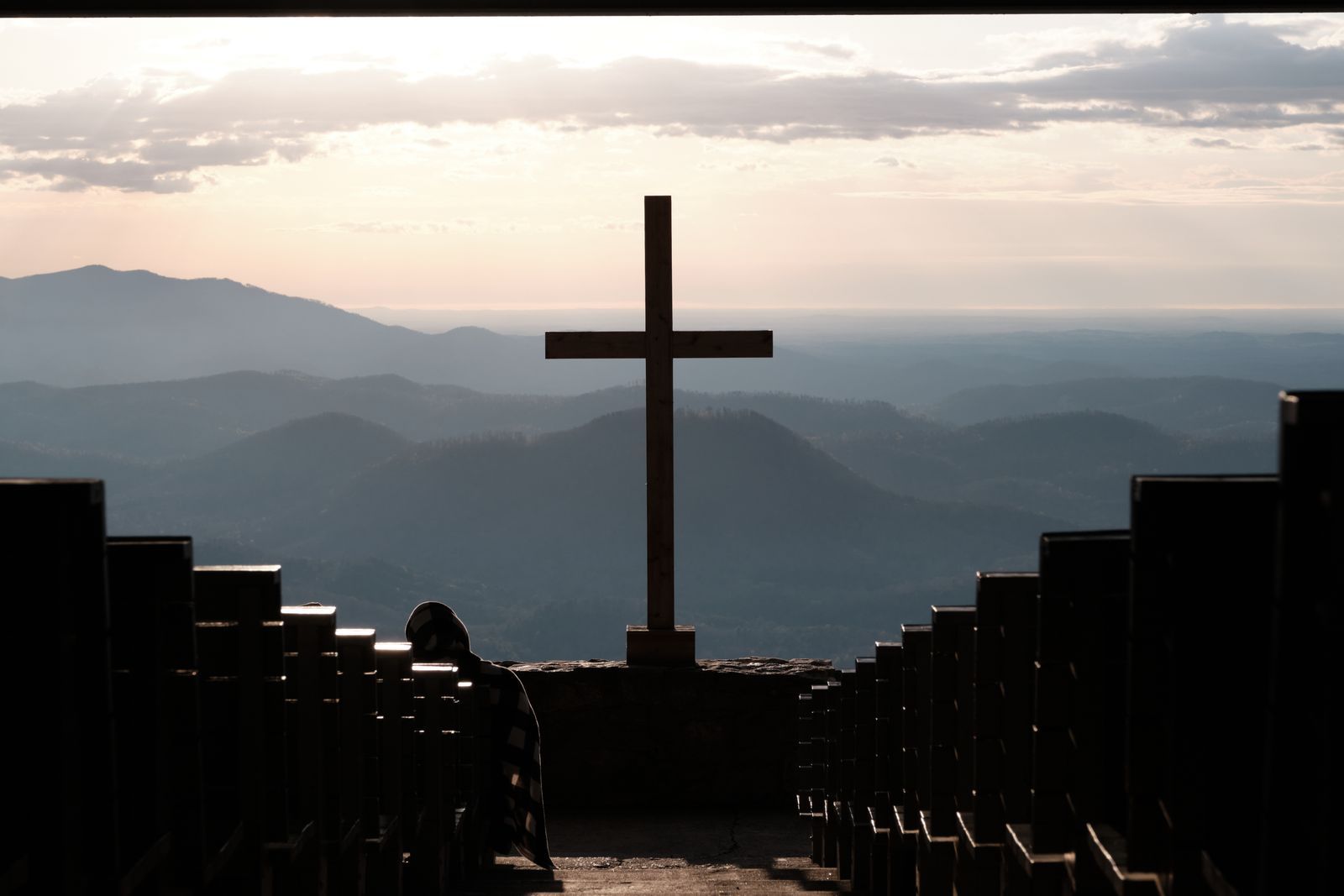 A cross on a hilltop at sunrise